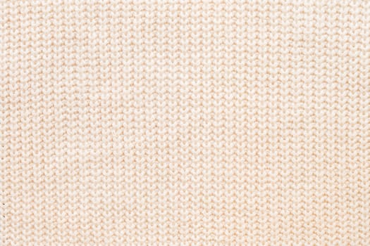Abstract knitted background. Wool beige sweater texture. Close up picture of knitted pattern.