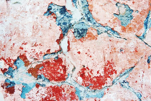 Stone background of old wall with peeling paint. Shabby texture of red and blue colored wall.