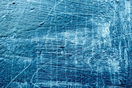 Abstract background with textured strokes of blue paint on the wooden surface.