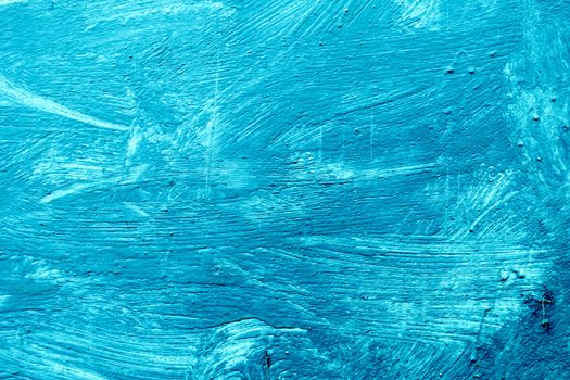 Abstract background with textured strokes of blue paint on the wooden surface.