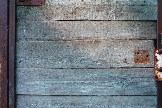 Wooden background of old door with rusty accessories.