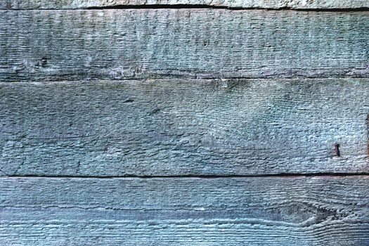 Wooden background of old fence with rusty nails. Shabby texture of blue colored wooden boards.