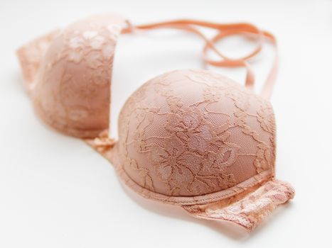 Beige lace bra on white background. Elegant underwear.