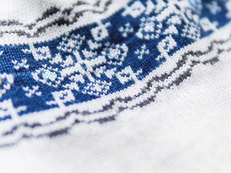 Knitted nordic pattern with blue snowflakes. Fabric with traditional scndinavian ornament. Warm outerwear.