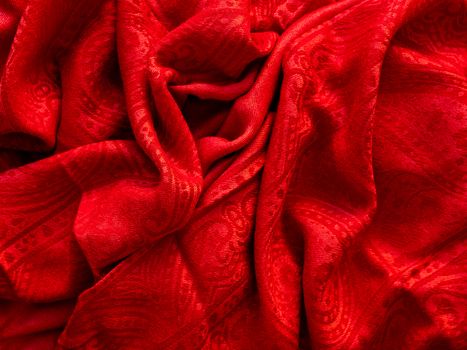 Bright red scarf. Folded warm accessory. Textile background.