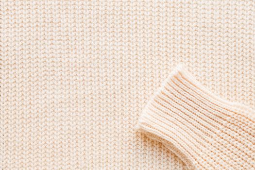 Abstract knitted background. Wool sweater with sleeves. Close up picture of knitted pattern.
