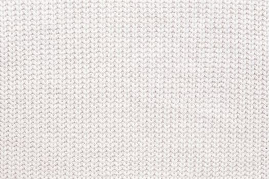 Abstract knitted background. White woolen sweater texture. Close up picture of knitted pattern.