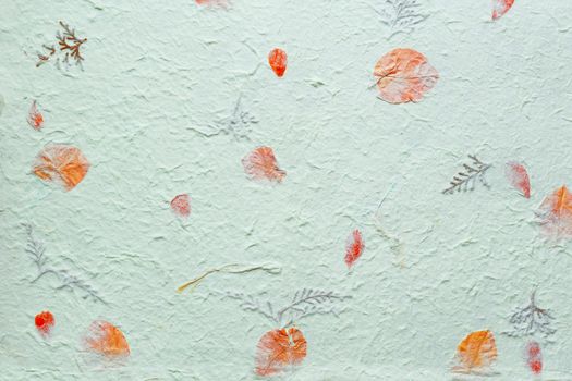 Abstract texture background. Handmade wrinkled paper with pieces of leaves.