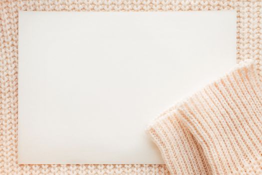 Abstract knitted background with clear paper. Wool sweater with sleeves. Close up picture of knitted pattern.