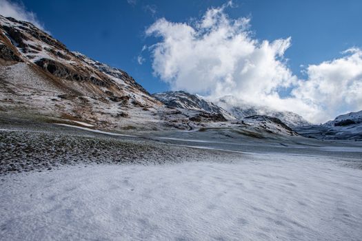 Alpine pass in switzerland, Julierpass in swiss alp with snow and cloudy sky