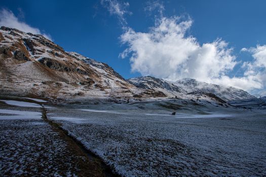 Alpine pass in switzerland, Julierpass in swiss alp with snow and cloudy sky
