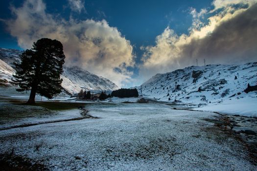 Alpine pass in switzerland, Julierpass in swiss alp with snow and cloudy sky