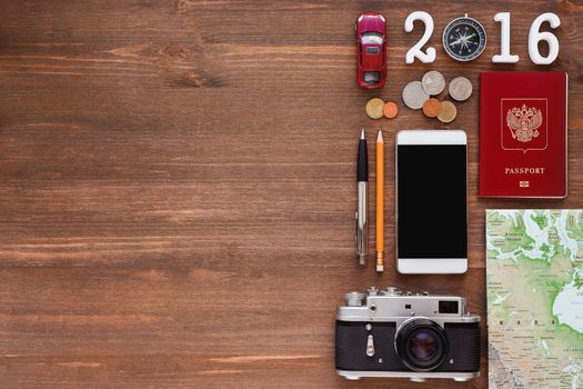 Travel background 2016 year. Different things you need for journey - smartphone, passport, camera, map, money. Symbols of car trip in 2016 year. Place for text.