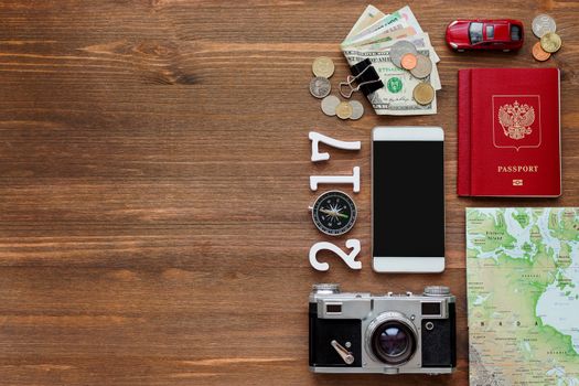 Travel background 2017 year. Different things you need for journey - smartphone, passport, camera, map, money. Symbols of car trip in 2017 year. Place for text.
