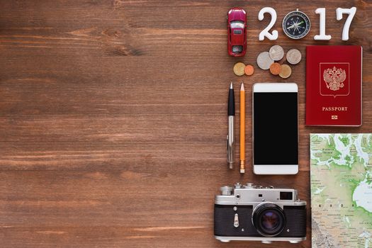 Travel background 2017 year. Different things you need for journey - smartphone, passport, camera, map, money. Symbols of car trip in 2016 year. Place for text.