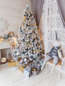 Christmas and New Year Eve Tree. Holiday winter background. Interior details - mirror-snowflake, mantelpiece with garland of light bulbs, many presents and elf with gifts.