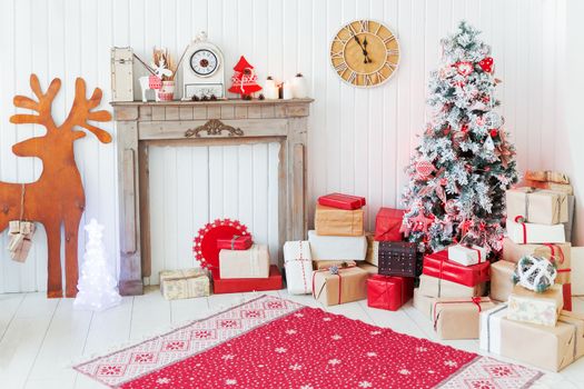 Christmas and New Year details of home interior - wooden deer, mantelpiece with candles, Eve tree and presents.