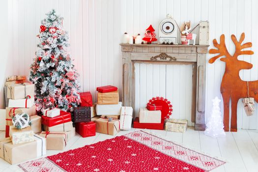 Christmas and New Year details of home interior - wooden deer, mantelpiece with candles, Eve tree and presents.