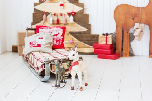 Vintage sledge with toy deer and horse. Christmas and New Year details of home interior.