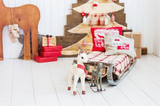 Vintage sledge with toy deer and horse. Christmas and New Year details of home interior.