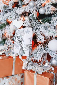 Christmas and New Year background with presents under the Eve Tree. Holiday winter background. Many gifts wrapped in golden and silver paper with bows.