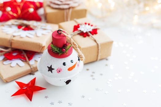 Christmas and New Year background with Snowman decorative ball, presents and decorations for Christmas tree. Holiday background with stars confetti and light bulbs. Place for text.