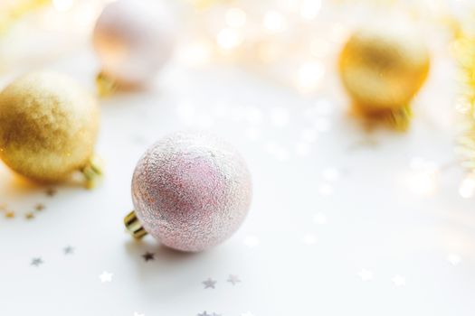 Christmas and New Year background with golden decorative balls for Christmas tree with light bulbs and confetti. Place for text.