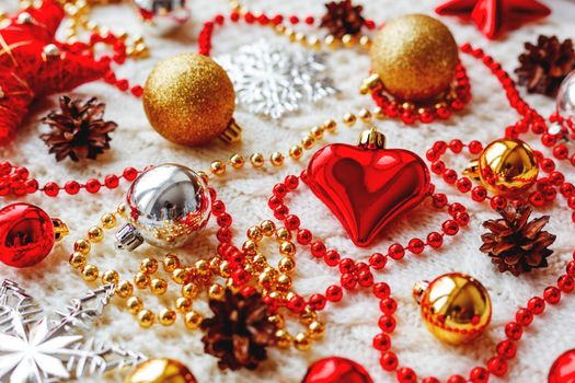 Christmas and New Year background with decorations - balls, stars, silver sparkling snowflakes, heart on knitted fabric with decorative pattern.