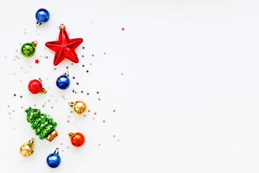Christmas background with decorations. New Year symbol - fir tree. Shiny colorful balls, star and confetti. Flat lay, top view. Place for text.
