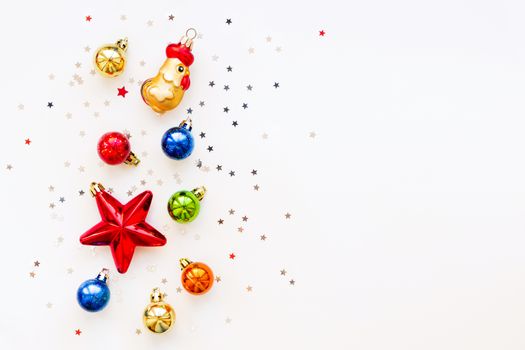Christmas background with decorations. Shiny colorful balls, star and confetti. Flat lay, top view. Place for text.