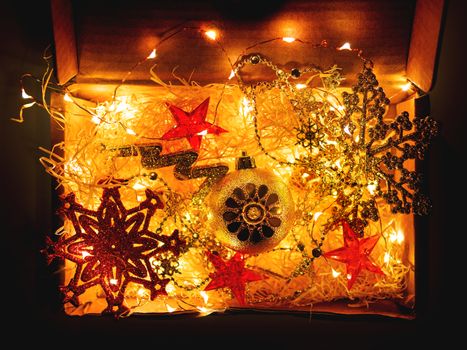 Cardboard box with Christmas and New Year decorations and light bulbs.