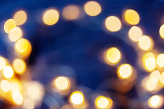 Defocused night street lights, blurred colorful bokeh background. Holiday colorful lanterns and light bulbs garlands.