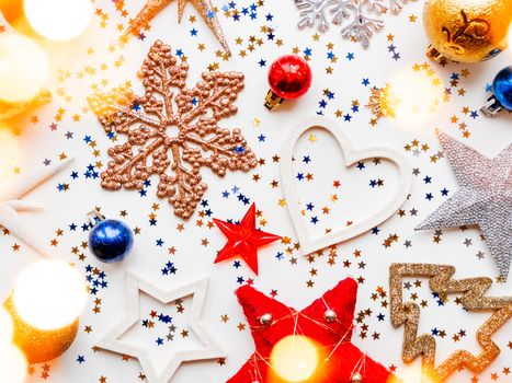 Christmas and New Year background with decorations - shiny stars, balls, snowflakes, light bulbs and confetti.