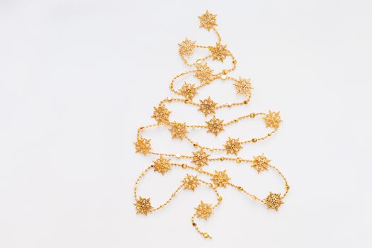 Christmas Tree made of golden snowflake garland. New Year symbol with place for text. Flat lay, top view.