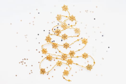 Christmas Tree made of golden snowflake garland with silver star confetti. New Year symbol with place for text. Flat lay, top view.