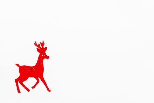 Wooden red running deer, Christmas and New Year decoration. Flat lay on white background, top view. Place for text.
