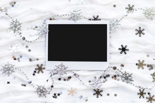 Winter background with decorative sparkling snowflakes. Empty photo frame for your picture or text.
