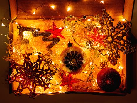 Cardboard box with Christmas and New Year decorations and light bulbs.