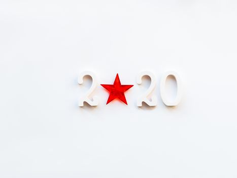 New Year 2020 background with bright red star. Numbers 2020 on white copy space with decorative ball for Christmas tree.