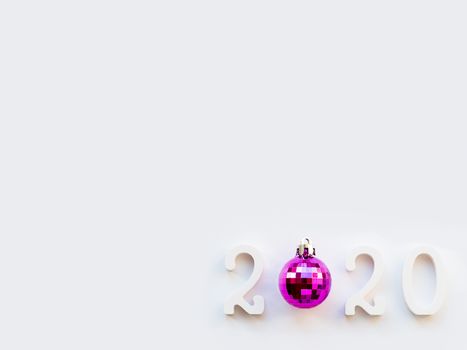 New Year 2020 background with purple ball. Numbers 2020 on white copy space with decorative ball for Christmas tree.