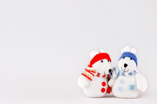 Pair of cute plush rabbits in warm clothes. Sweet couple of toys in scarfs and caps. Christmas background with empty space for text.