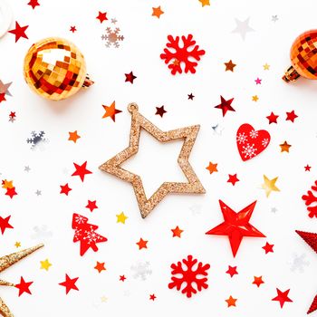 Christmas and New Year holiday background with decorations. Shiny red balls, golden snowflakes and star confetti. Flat lay, top view.