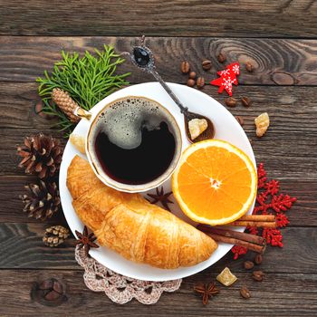 Christmas and New Year 2017 background with continental breakfast - cup of hot coffee with cinnamon, fresh orange and croissant. Decorations - snowflake, crochet napkin, pine cones.