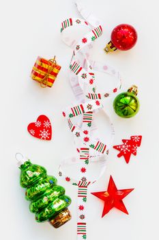 Ribbon with Christmas pattern - nordic geometric snowflakes. New Year decorations - bright colorful balls, fir tree, star. Place for text. Flat lay, top view.
