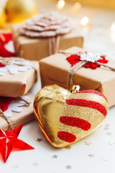 Christmas and New Year background with presents and decorative heart for Christmas tree. Holiday background with stars confetti and light bulbs.