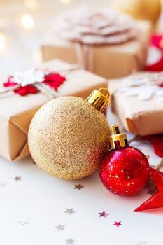Christmas and New Year background with golden decorative ball, presents and decorations for Christmas tree. Holiday background with stars confetti and light bulbs. Place for text.