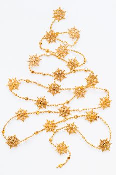 Christmas Tree made of golden snowflake garland. New Year symbol with place for text. Flat lay, top view.