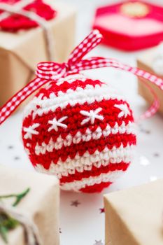 Christmas and New Year background with presents, decorations and crocheted handmade decorative ball.