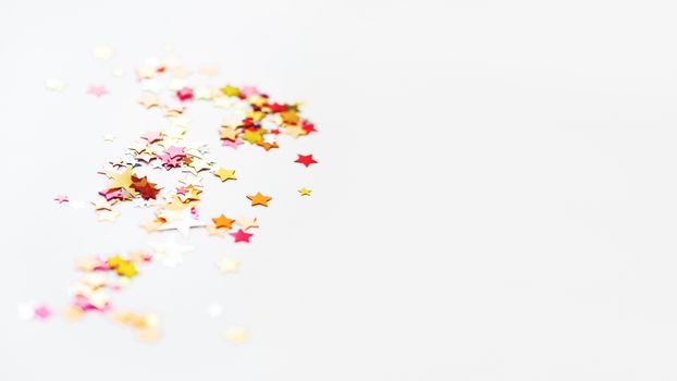 White holiday background with colorful star confetti. Good background for Christmas and New Year cards.