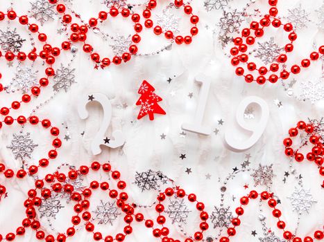 Christmas and New Year background with numbers 2019, red fir tree, silver decorations and light bulbs.